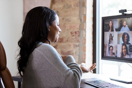 Kvinne sitter ved PC med Teamsmøte på skjermen