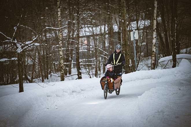 Bilde av kvinne og barn på lastesykkel vinterstid