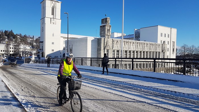 Vintersyklist sykler foran rådhuset