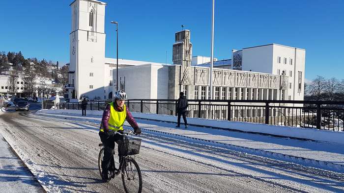 Vintersyklist sykler foran rådhuset