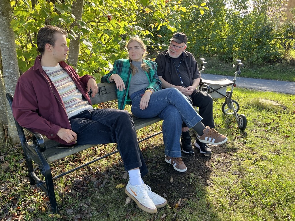 Tre personer på en benk