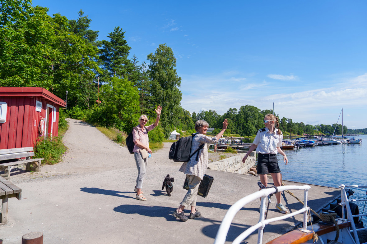 Venninnene Grethe og Irene går av på Brønnøya Sør og vinker farvel til Rigmor. Foto: Espen Wang-Naveen