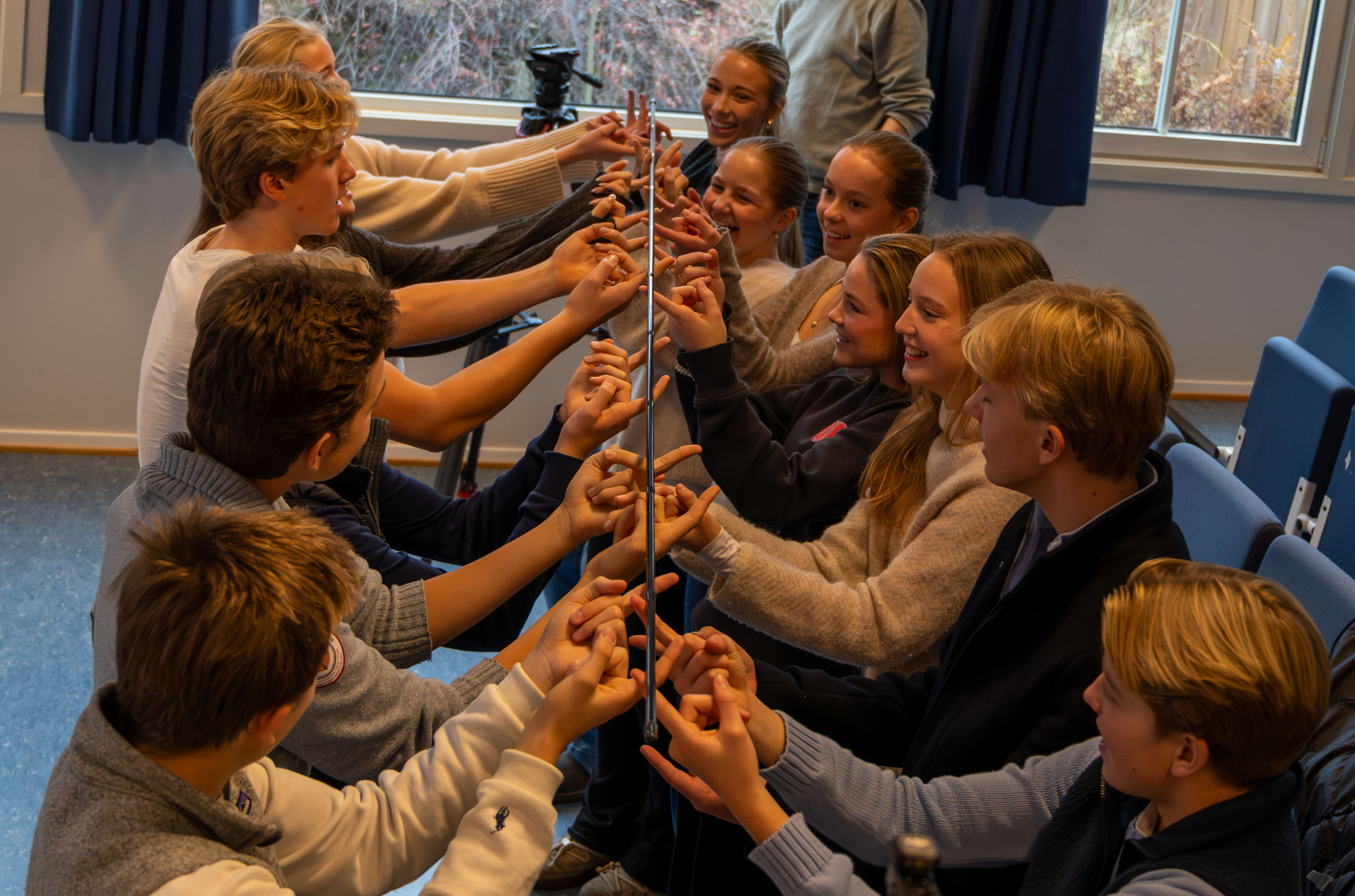 Elever samarbeider for å få en pinne ned til gulvet. Det er vanskeligere enn de trodde.