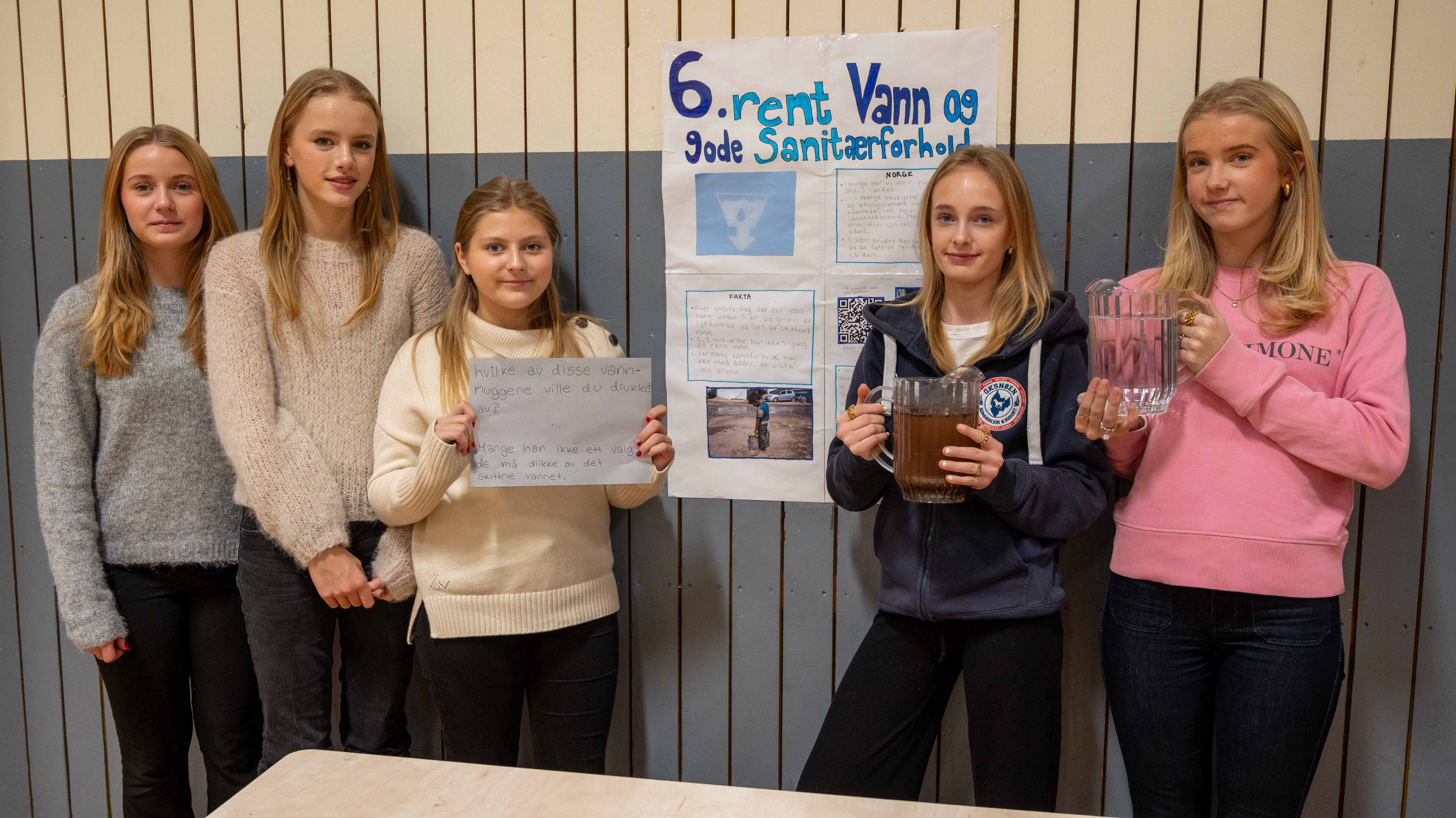 Elever har lært om rent vann og gode sanitærforhold. Holder frem vannkanne med rent vann, og en med skittent vann for å illustrere ulikheter i verden.