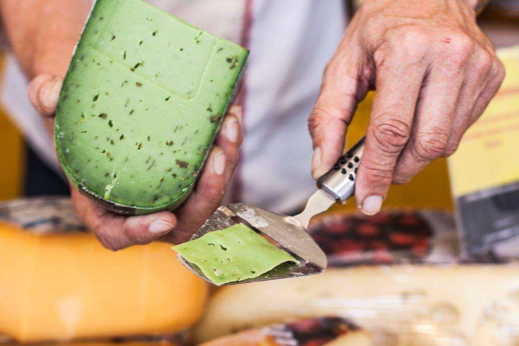 Matmarked bilde av en som skjærer en ost