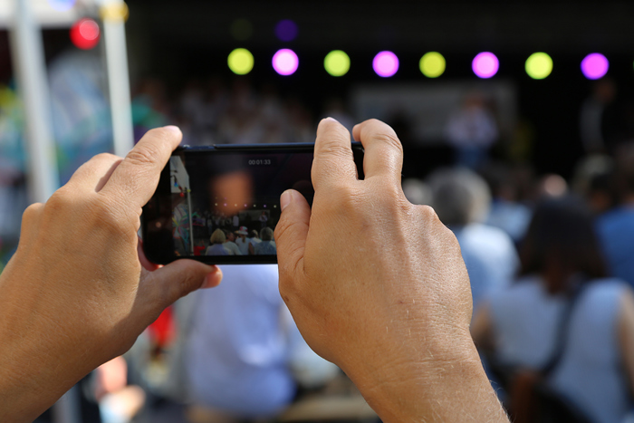 Person tar bilde med sin mobil på konsert