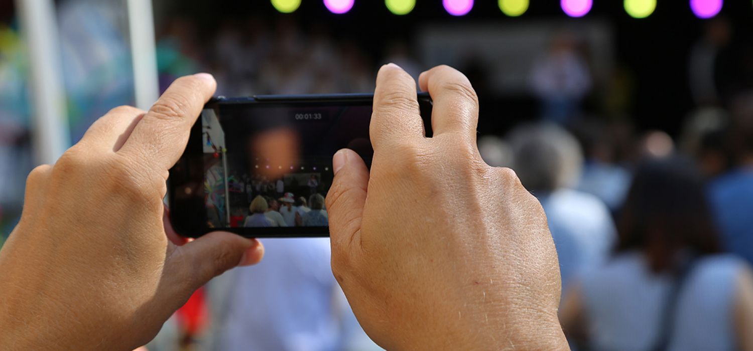 Person tar bilde med sin mobil på konsert