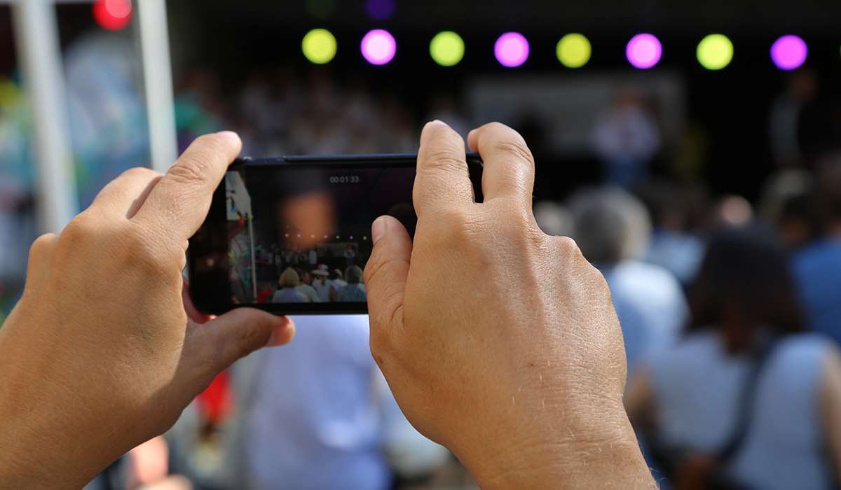 Person tar bilde med sin mobil på konsert