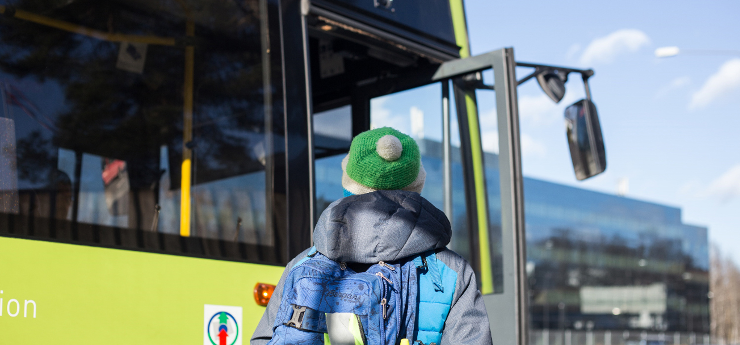 Bussholdeplass - gutt med lue som skal gå på bussen